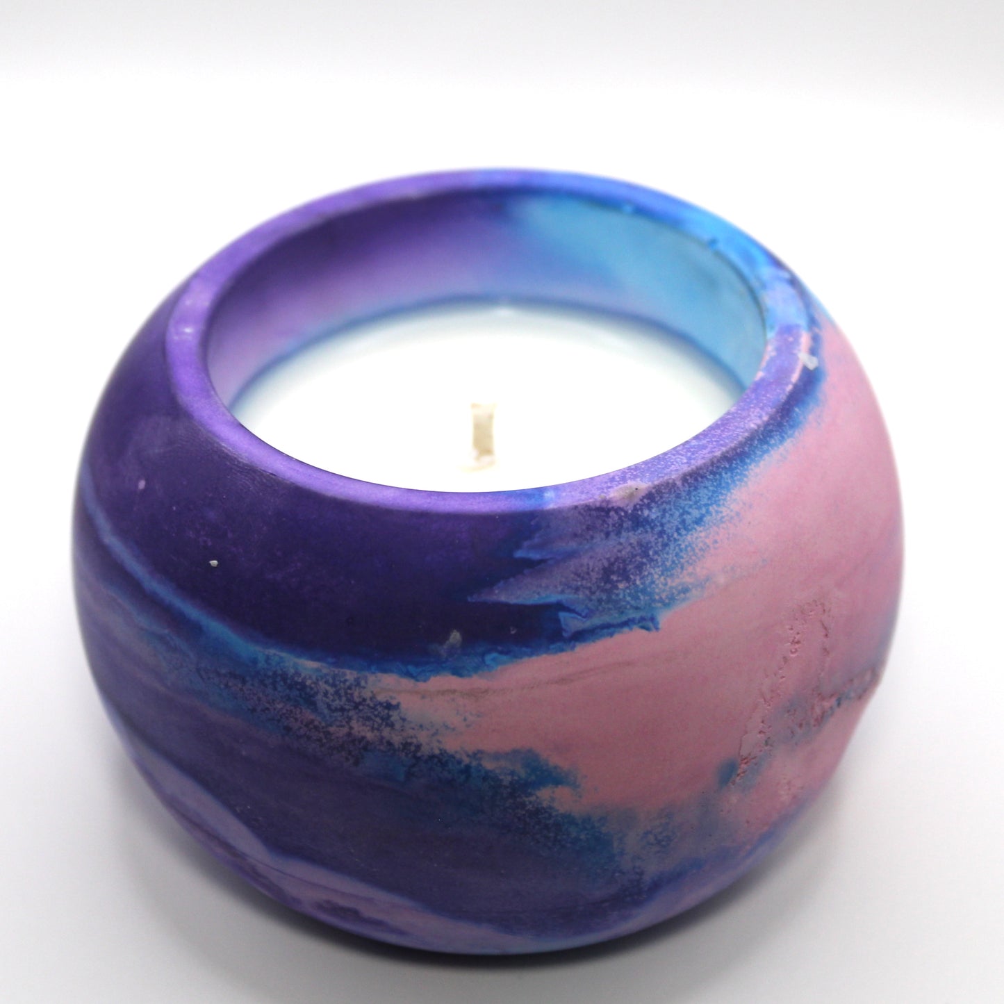 3/4 top-down view of a handcrafted candle holder, showcasing the Pink, blue and purple colors of the bisexual pride flag seamlessly blending together with the white candle clearly visible. Set against a clean white background, this unique design celebrates identity and expression. Ideal for LGBTQ+ home decor, pride gifts, and statement lighting