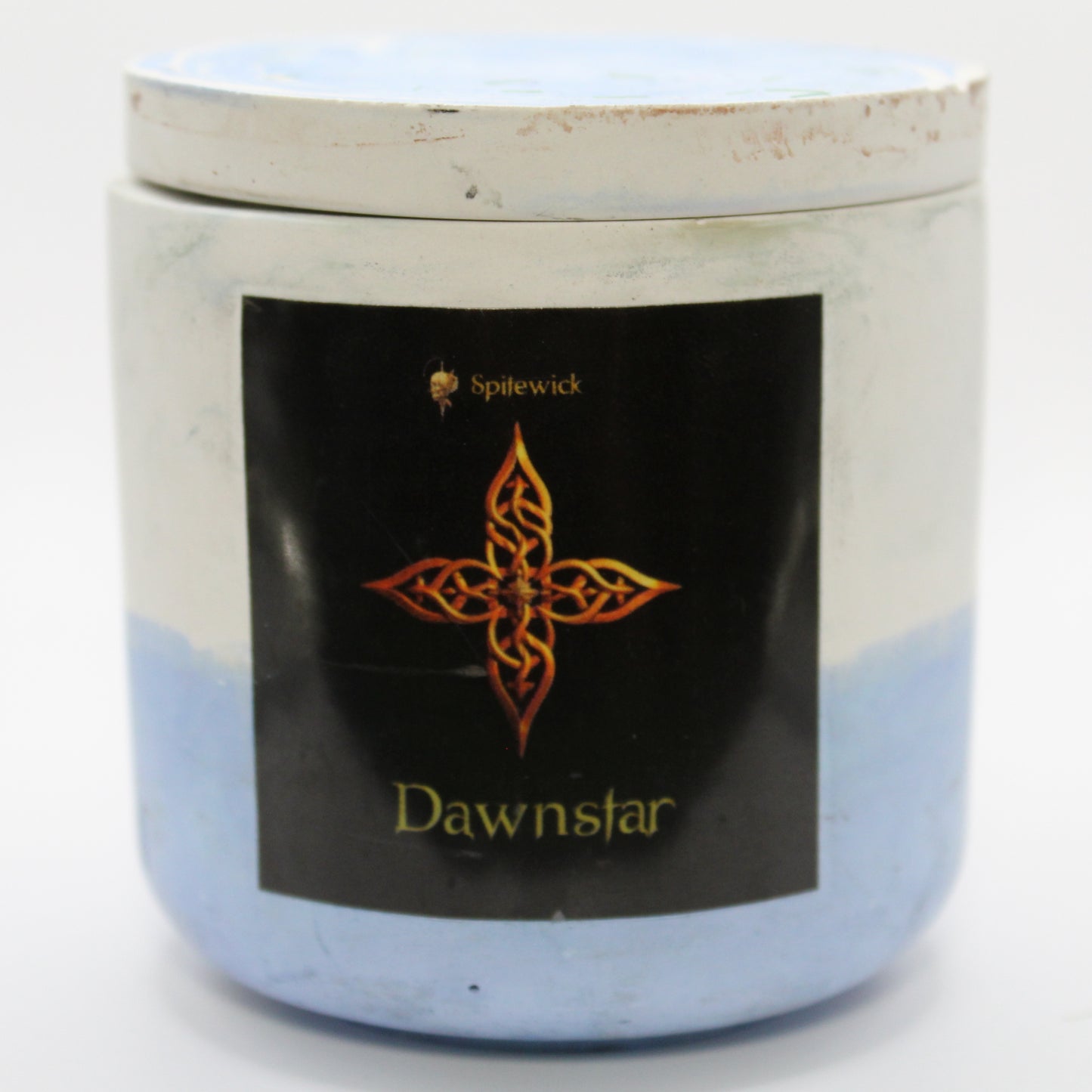 A white and blue candle holder with a sleek black label, featuring an four pointed star intricately designed in stylized gold Celtic knotwork. Beneath the design, the name Dawnstar is elegantly printed in gold, adding a bold yet sophisticated touch. Set against a clean white background, this handcrafted candle blends tradition with modern artistry, perfect for unique home decor, gifts, and personal expression.