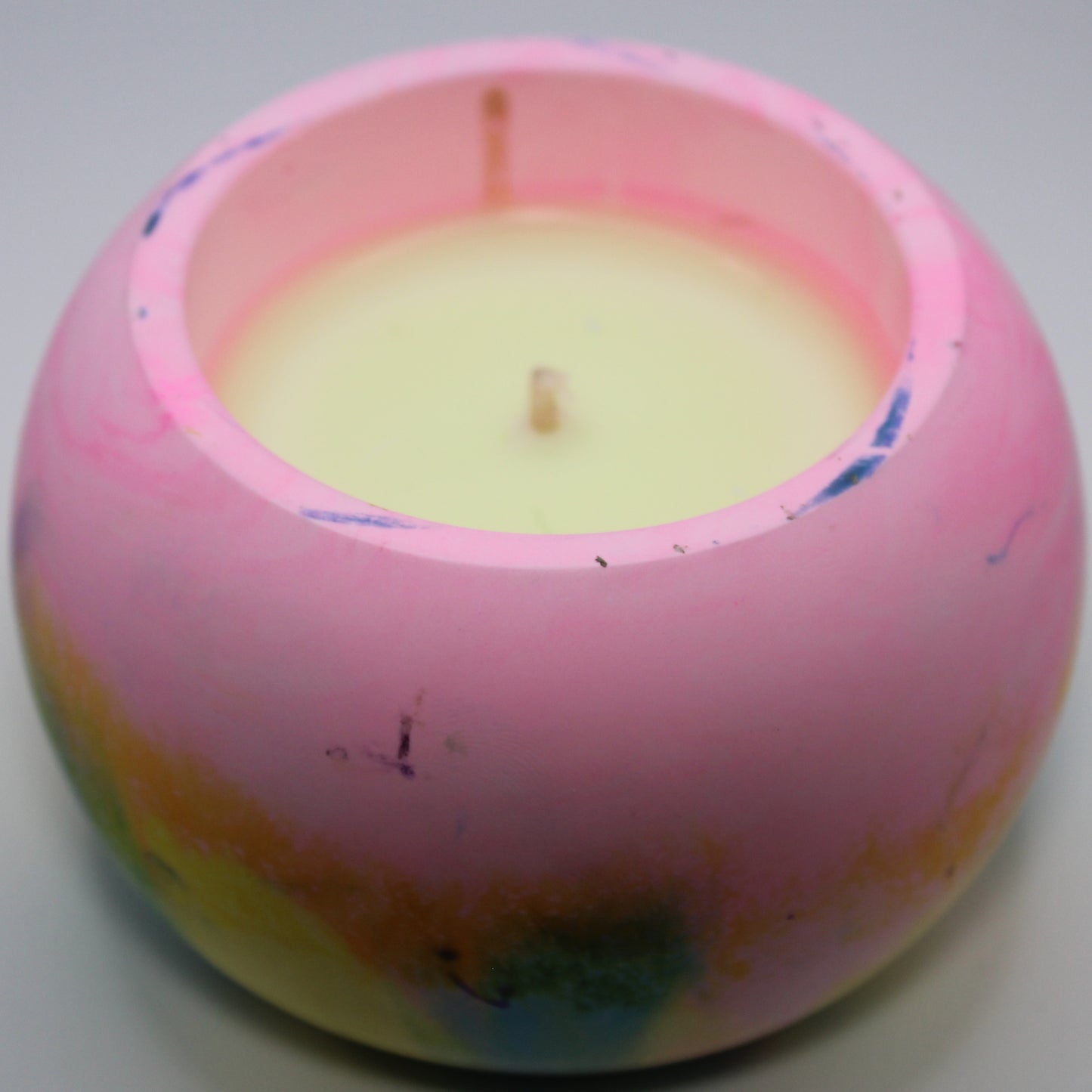 3/4 top-down view of a handcrafted candle holder, showcasing the vibrant colors of the pansexual pride flag seamlessly blending together with the yellow candle clearly visible. Set against a clean white background, this unique design celebrates identity and expression. Ideal for LGBTQ+ home decor, pride gifts, and statement lighting.