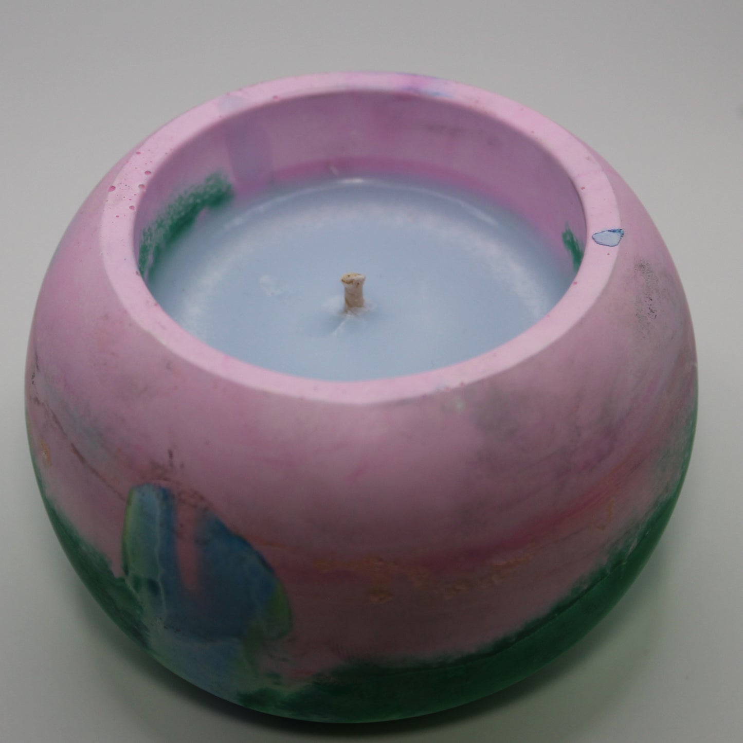 3/4 top-down view of a handcrafted candle holder, showcasing the vibrant colors of the polysexual pride flag seamlessly blending together with the blue candle clearly visible. Set against a clean white background, this unique design celebrates identity and expression. Ideal for LGBTQ+ home decor, pride gifts, and statement lighting.