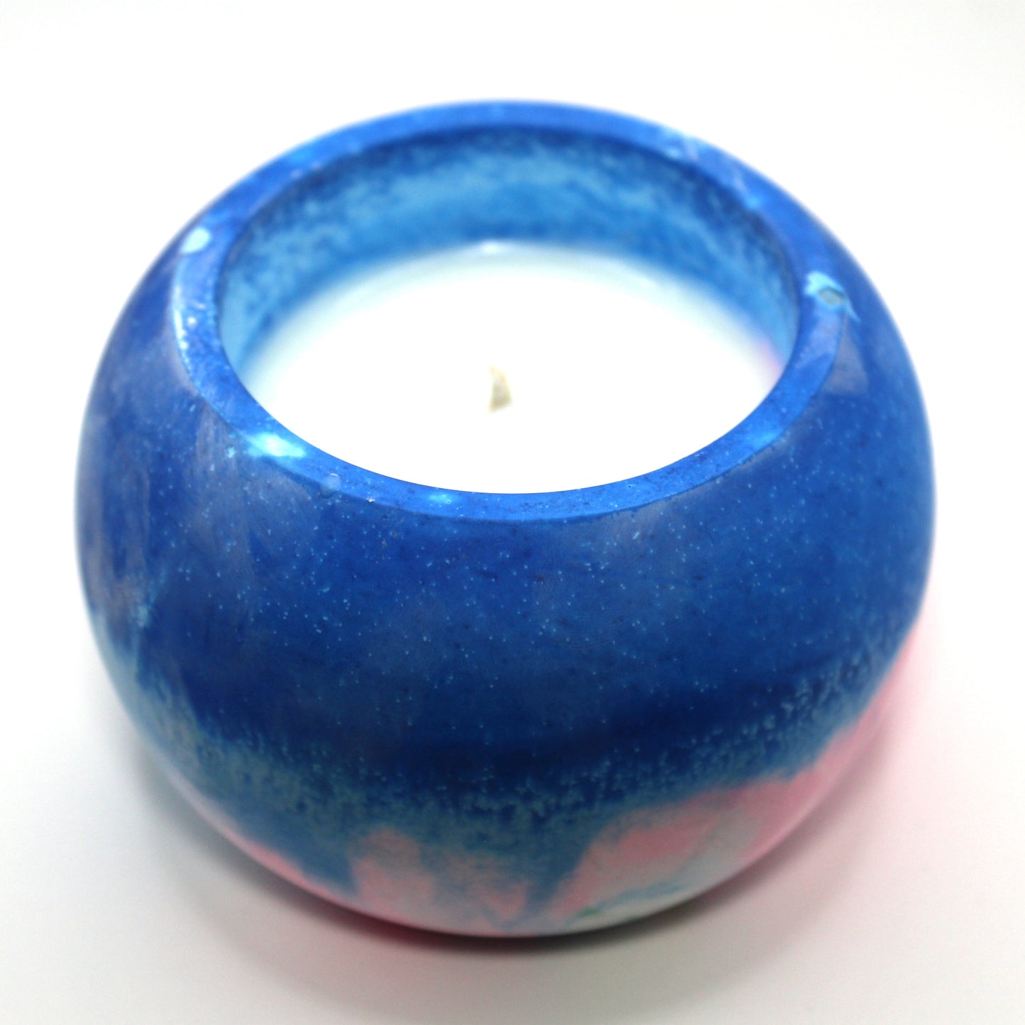 3/4 top-down view of a handcrafted candle holder, showcasing the vibrant colors of the transgender pride flag (pink, white and blue) seamlessly blending together with the white candle clearly visible. Set against a clean white background, this unique design celebrates identity and expression. Ideal for LGBTQ+ home decor, pride gifts, and statement lighting.