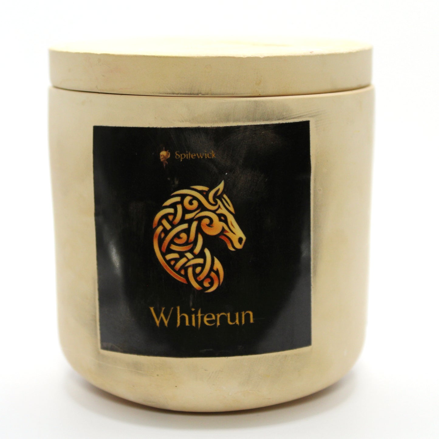 A beige candle holder with a sleek black label, featuring a horse intricately designed in stylized gold Celtic knotwork. Beneath the design, the name Whiterun is elegantly printed in gold, adding a bold yet sophisticated touch. Set against a clean white background, this handcrafted candle blends tradition with modern artistry, perfect for unique home decor, gifts, and personal expression.