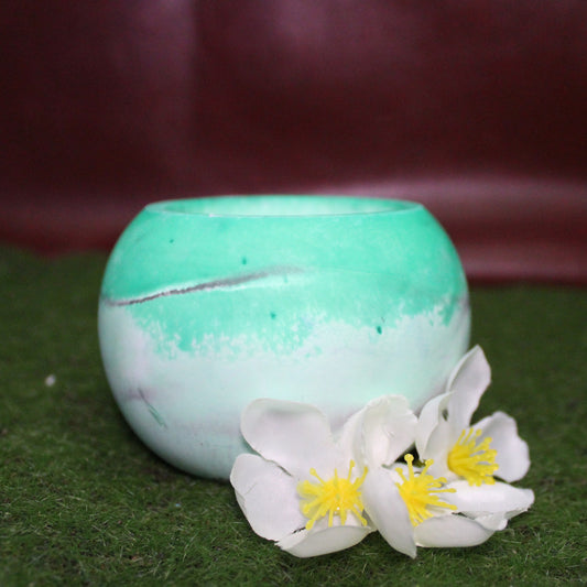 Handcrafted candle holder featuring the black, white and green hues of the agender pride flag, seamlessly blended together for a striking design. Set on grass with a burgundy vinyl backdrop, surrounded by white flowers mirroring the flag’s colors, creating a visually rich and identity-affirming scene. Perfect for LGBTQ+ home decor, pride gifts, and statement lighting.