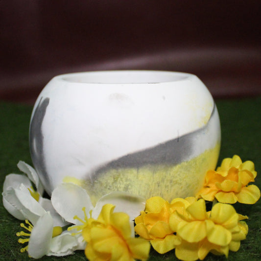 Handcrafted candle holder featuring the Black, white, and yellow hues of the Demigender pride flag, seamlessly blended together for a striking design. Set on grass with a burgundy vinyl backdrop, surrounded by an assortment of flowers mirroring the flag’s colors, creating a visually rich and identity-affirming scene. Perfect for LGBTQ+ home decor, pride gifts, and statement lighting.