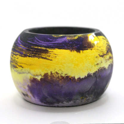 Handcrafted Ecocrete candle holder featuring the black, purple, yellow and white colors of the nonbinary pride flag, elegantly blended together. Set against a clean white background, this unique design celebrates identity and personal expression. Perfect for LGBTQ+ decor, pride gifts, and home ambiance.