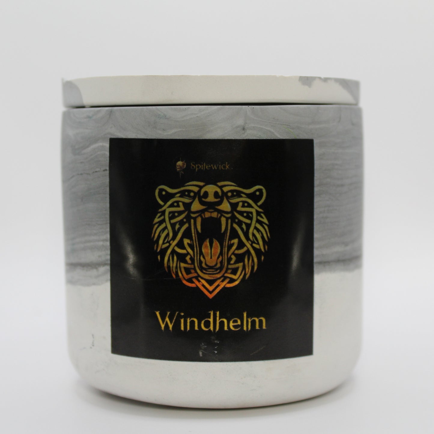 A black and white candle holder with a sleek black label, featuring a bear intricately designed in stylized gold Celtic knotwork. Beneath the design, the name Windhelm is elegantly printed in gold, adding a bold yet sophisticated touch. Set against a clean white background, this handcrafted candle blends tradition with modern artistry, perfect for unique home decor, gifts, and personal expression.